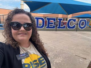 Chevonne Lorigo-Johst at a Pflugerville ISD campus, wearing her Board President badge.